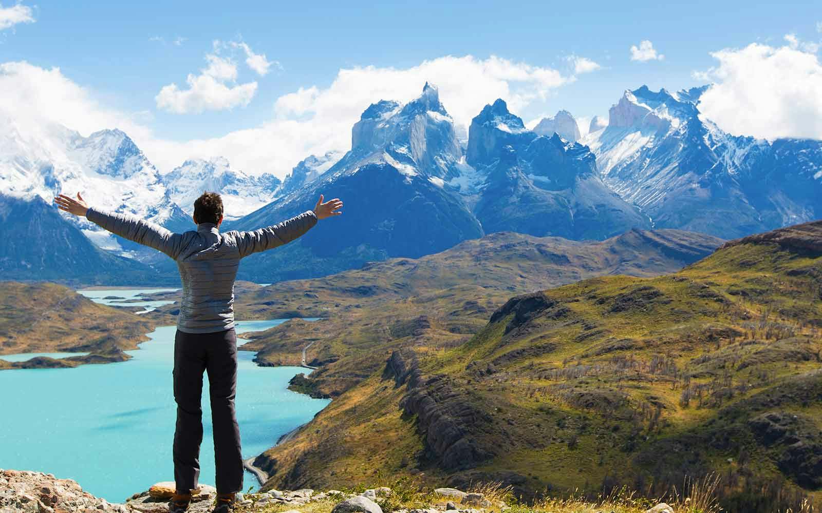 A man standing on top of a mountain with his arms outstretched.
