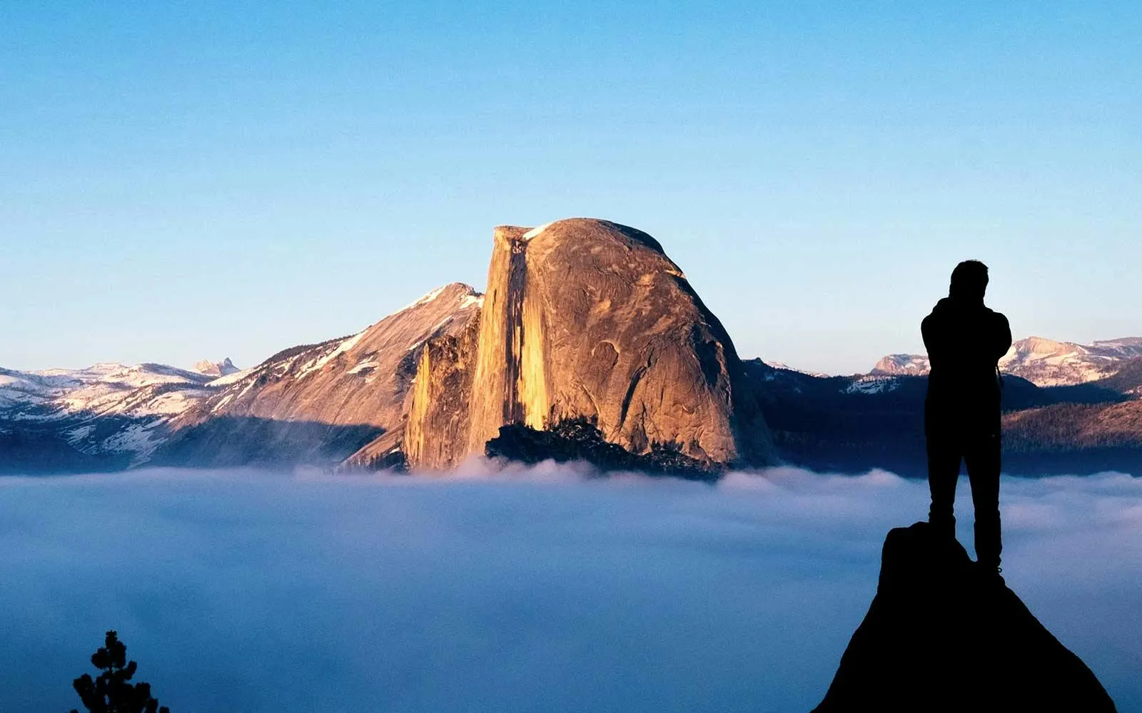 Man looking at Half Dome surrounded by fog in Yosemite National Park
