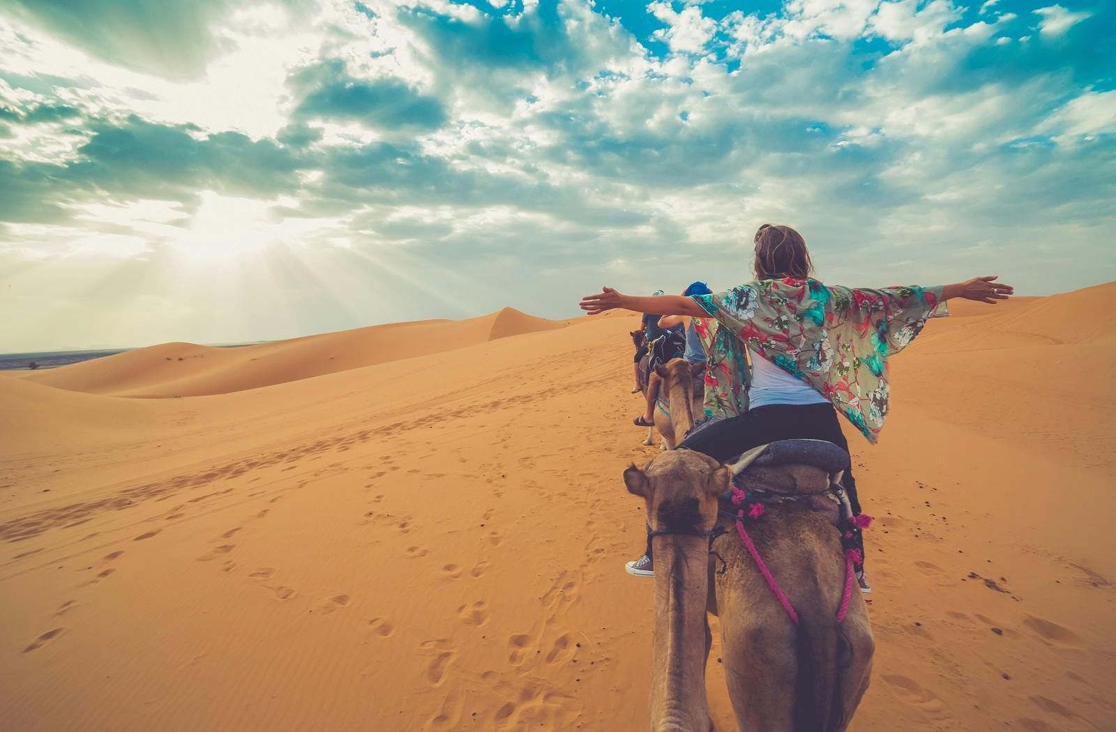A woman riding a camel in the desert.