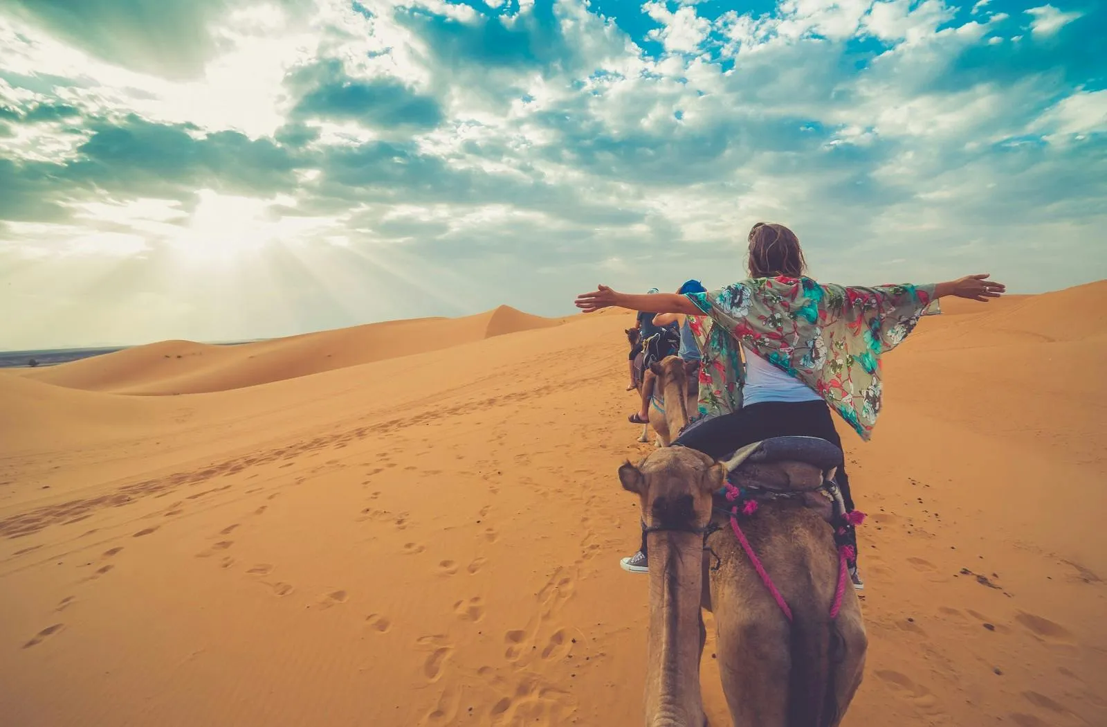 A woman riding a camel in the desert.