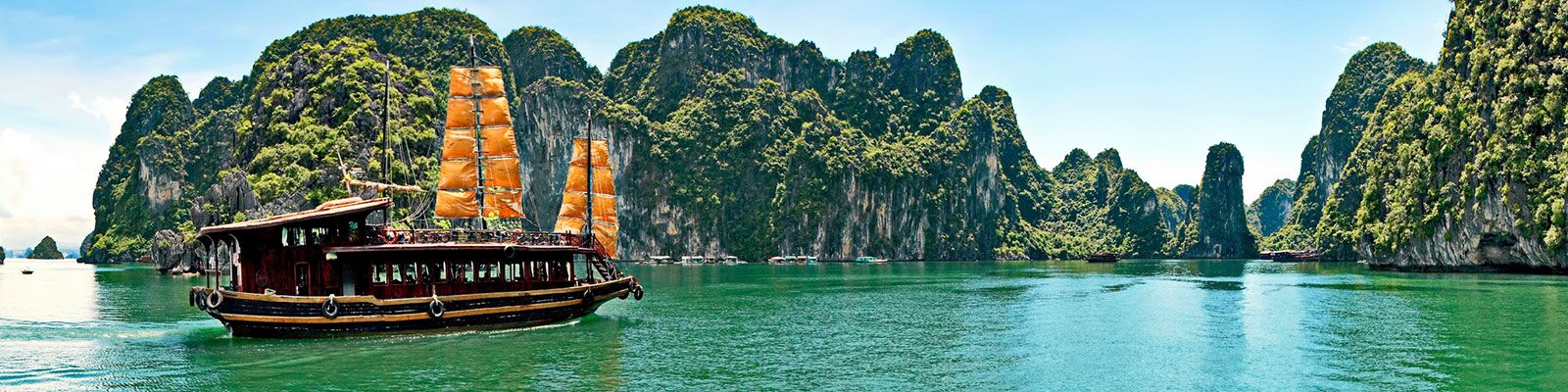 A boat is floating in the water near a mountain.